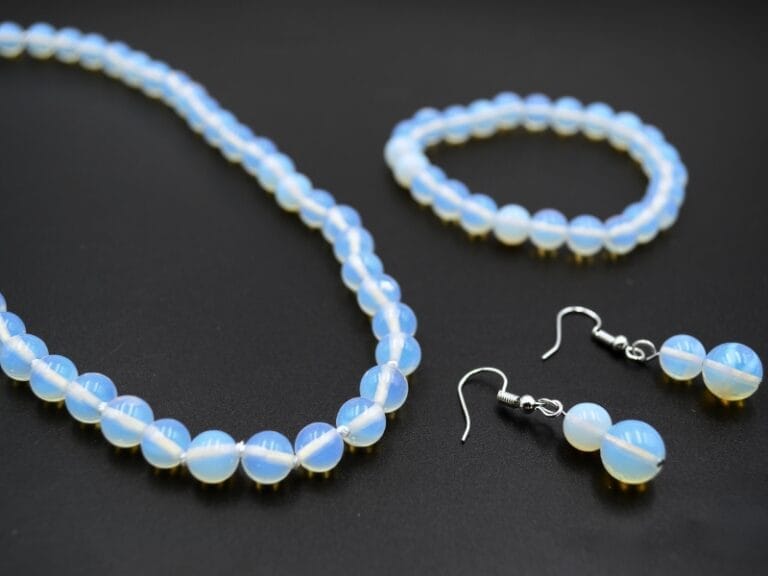 Set din Opalit, forma bila slefuita de 8 mm.  Colier cu lungimea de 45 cm, insirat pe ata cu accesorii metalice (nu contin Nichel). Bratara insirata pe elastic, marime M- aprox. 18 cm Cercei din 2 bile slefuite cu lungimea de 4 cm.
