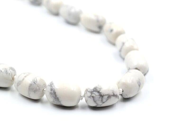 Colier din Hawlit Alb, forma bila ovala de 15 mm, insirat pe ata cu noduri intre margele si accesorii metalice (nu contin Nichel).