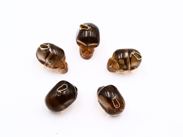 Pandant din Cuart fumuriu, forma de craniu sculptat manual de aprox. 2.5 x 2 cm si accesorii metalice (nu contin Nichel). Provenienta Brazilia.